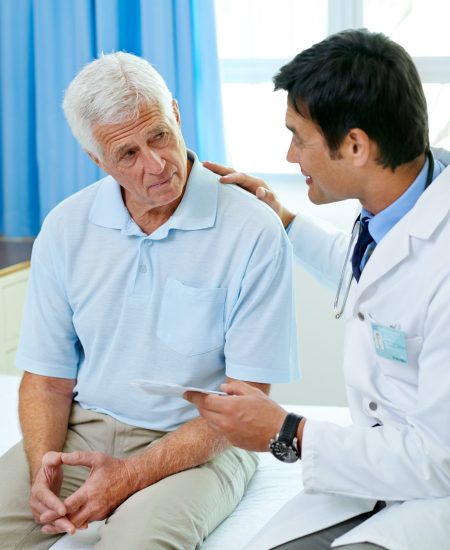 Consultation, doctor and old man in hospital room with advice, help and support from senior care clinic. Retirement, discussion on results and elderly patient sitting on bed with medical professional.